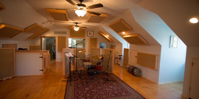 The tracking room with full drum set recording setup.